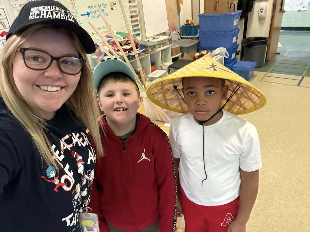 A teacher and students wearing fun hats. 