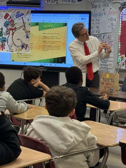 Meteorologist, Tom Atkins, talking to students in a classroom.