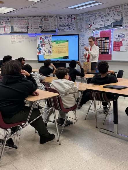 Meteorologist, Tom Atkins, talking to students in a classroom.