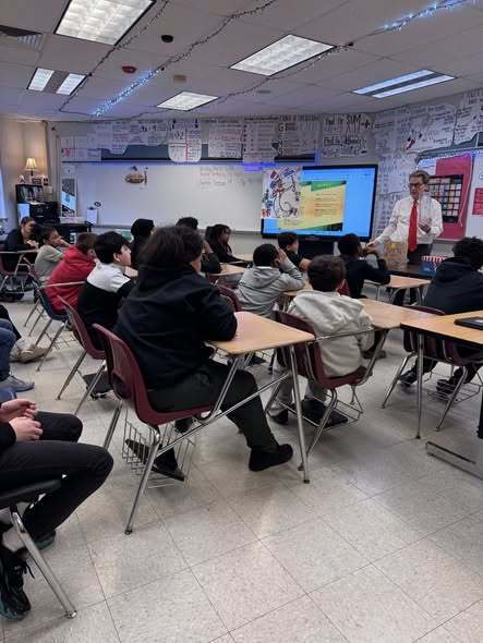 Meteorologist, Tom Atkins, talking to students in a classroom.