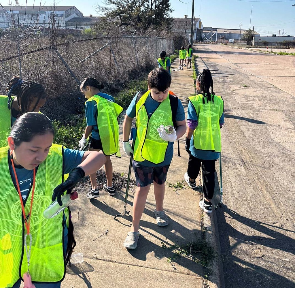 Elementary students picking up trash from the sidewalk