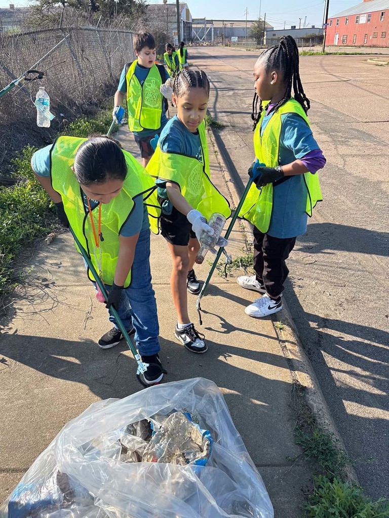 Elementary students picking up trash from the sidewalk