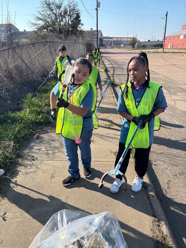 Elementary students picking up trash from the sidewalk