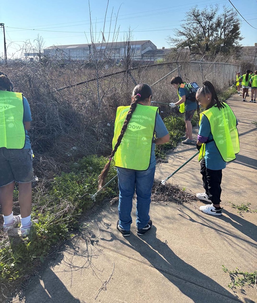 Elementary students picking up trash from the sidewalk