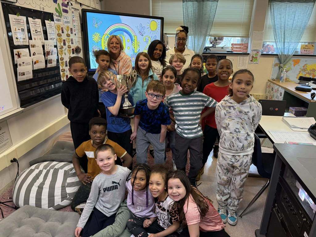 Students and teacher smiling in a classroom. 