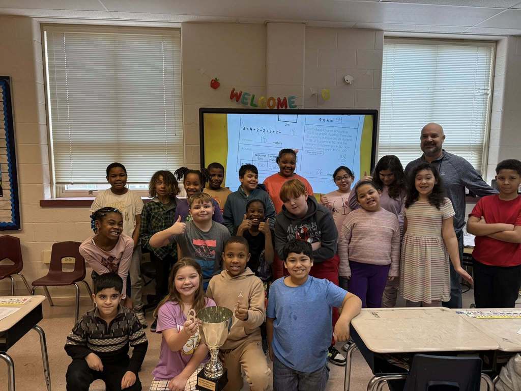 Students and teacher smiling in a classroom. 