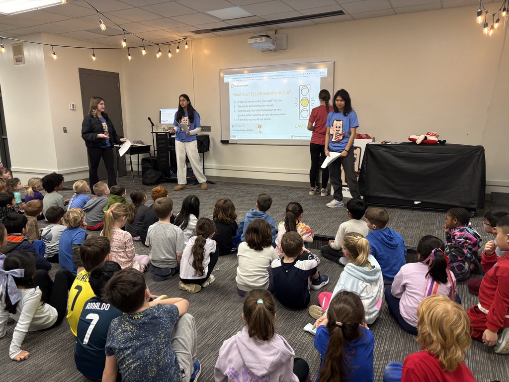 1st grade students watching the presenters speak on the traffic light for websites and apps. Students were looking at the slide on yellow websites and apps.