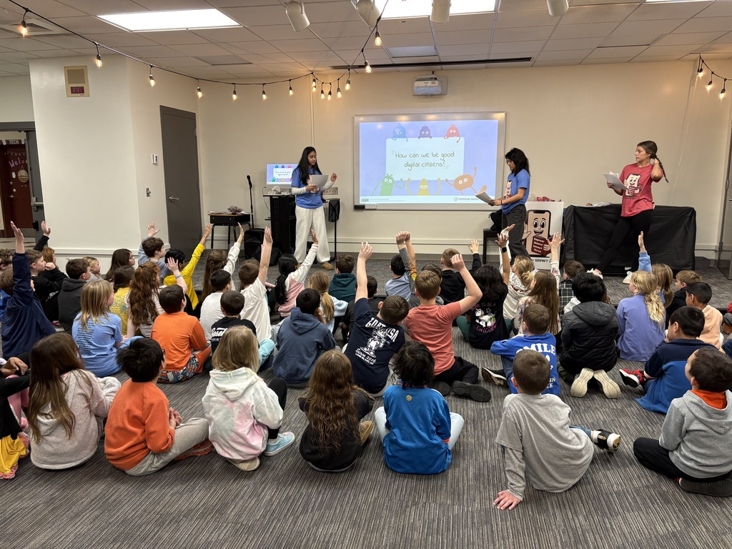 2nd grade students raising their hand to the question, "How can we be good digital citizens?"