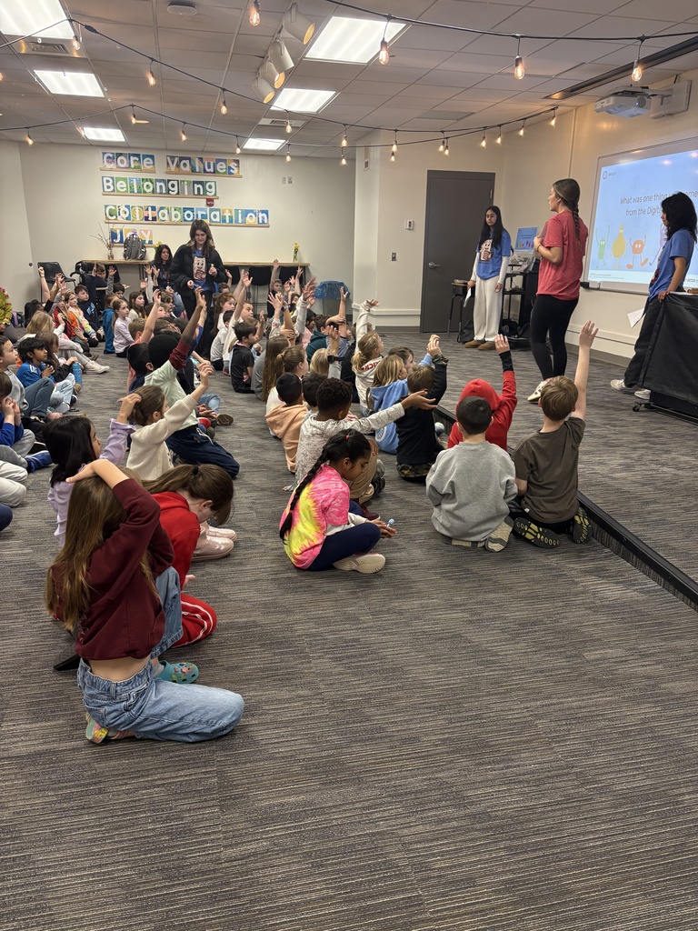2nd grade students raising their hand to answer questions related to "What was one thing you learned from the Digital Citizenship presentation?"