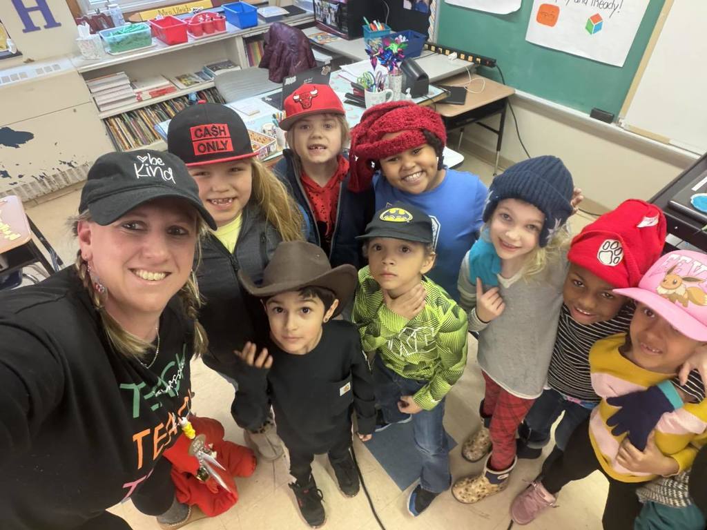 Teacher and students wearing striped shirts and fun hats.