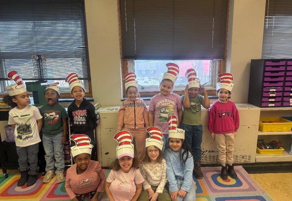 Group of students wearing cat in the hat paper hats.