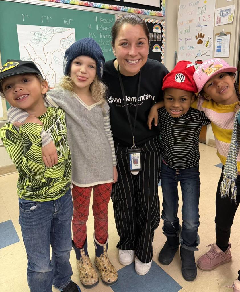 Teacher and students wearing striped shirts and fun hats.
