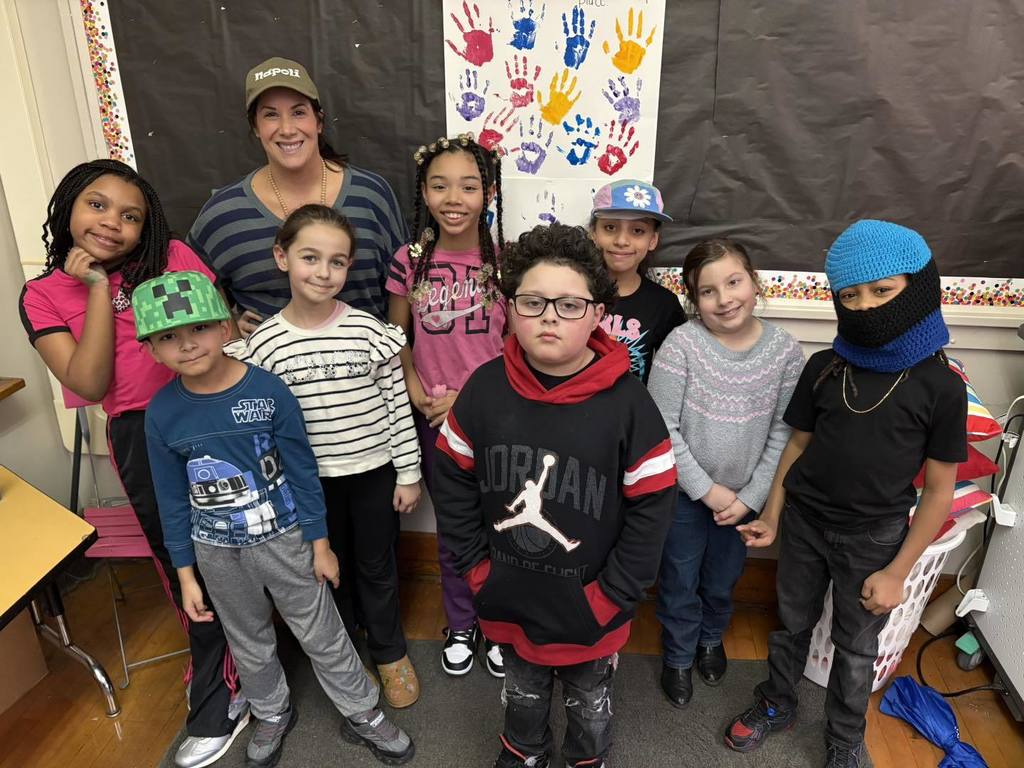 A teacher and students wearing fun hats and striped shirts.