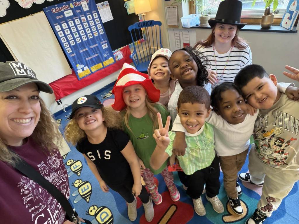 Teachers and students wearing stripped shirts and fun hats.