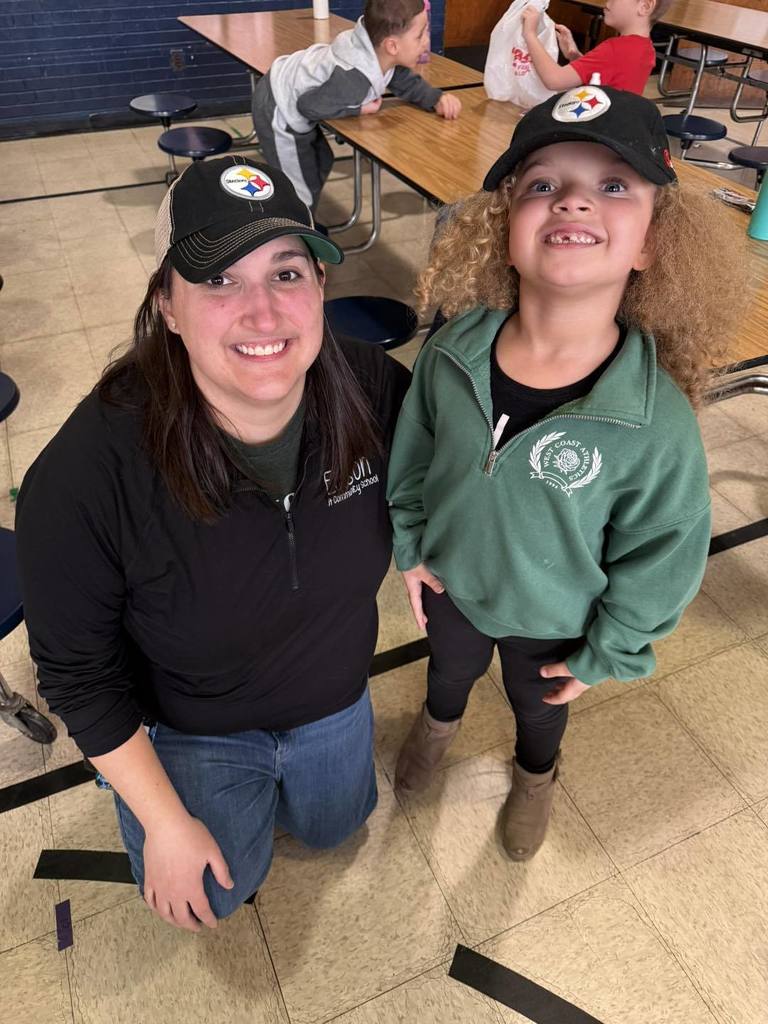 A teacher and student are both wearing stealers hats.