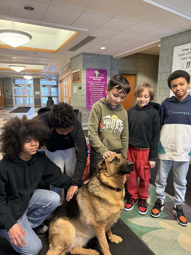 Students petting a dog. 