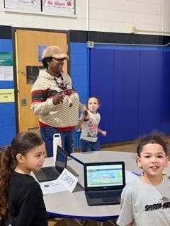 Teachers and students smiling in the cafeteria.
