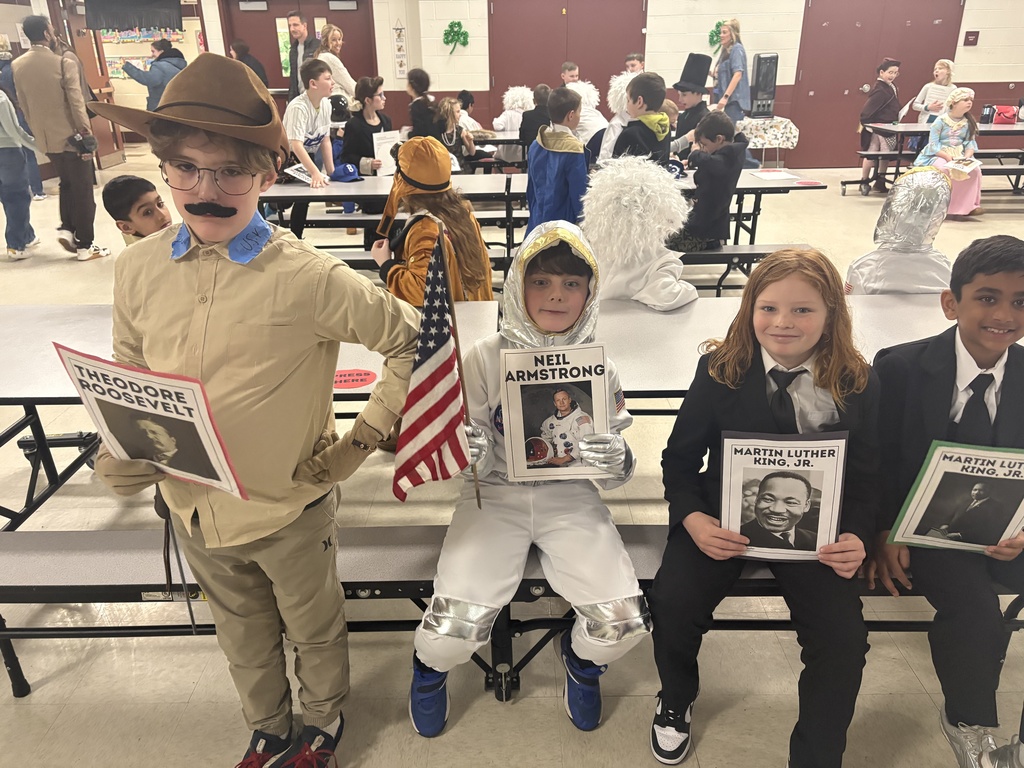 Theodore Roosevelt, Neil Armstrong, MLK Jr x 2 smiling with their posters.