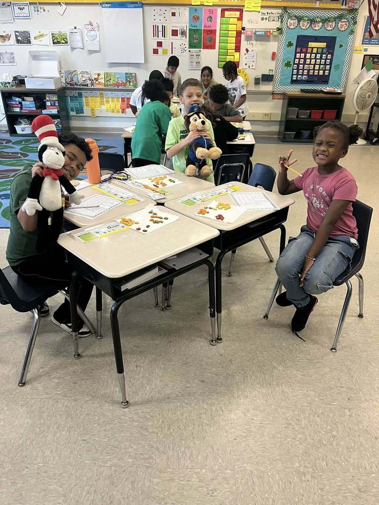 Students smiling while they do an activity at their desks in class. 