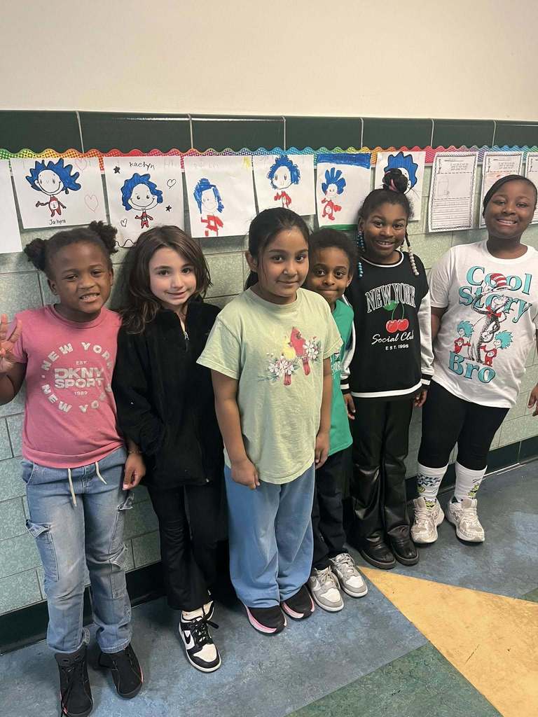 Students smiling in a school hallway. 