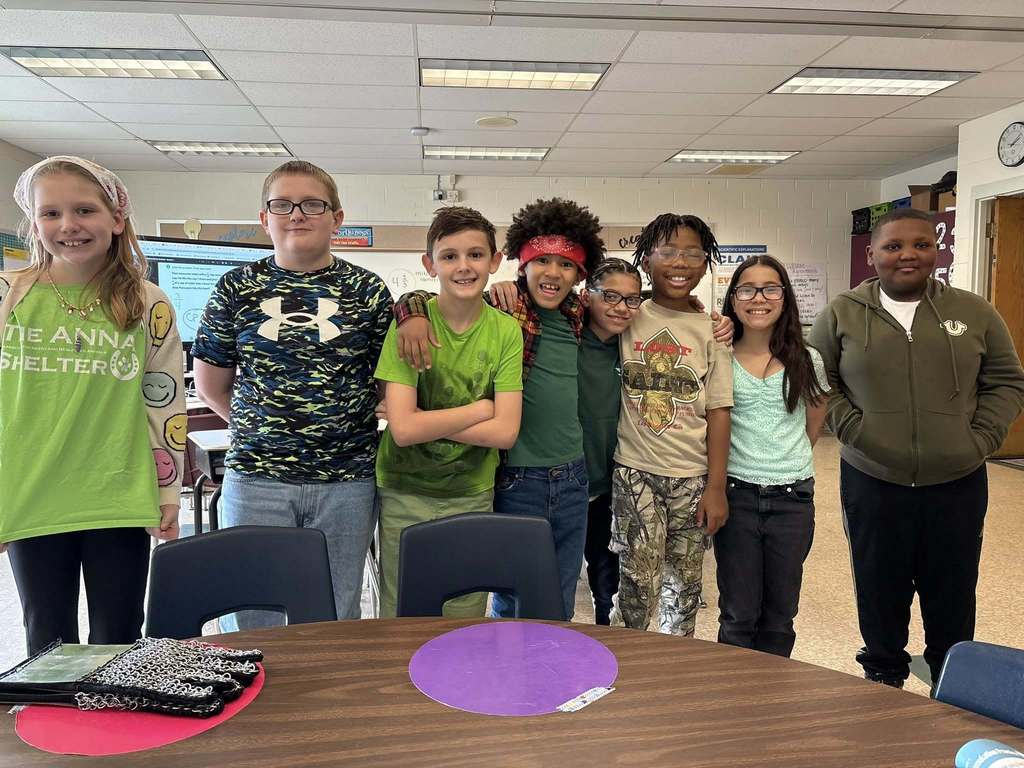 Kids wearing green and smiling in class. 
