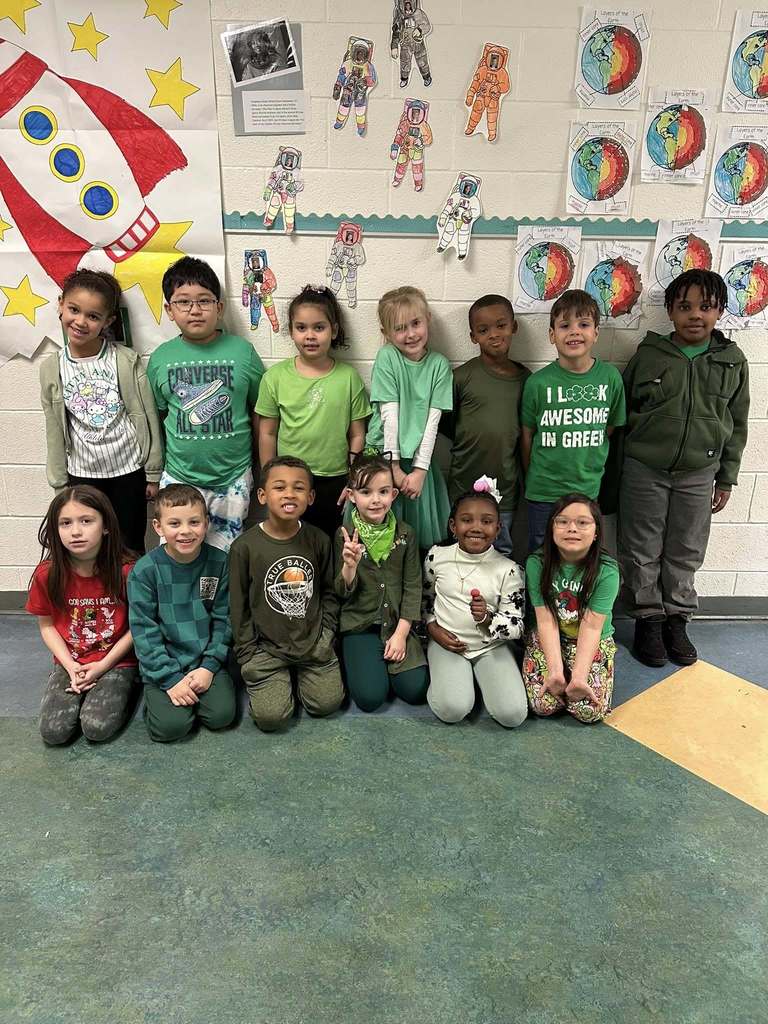 Students wearing green and smiling. 
