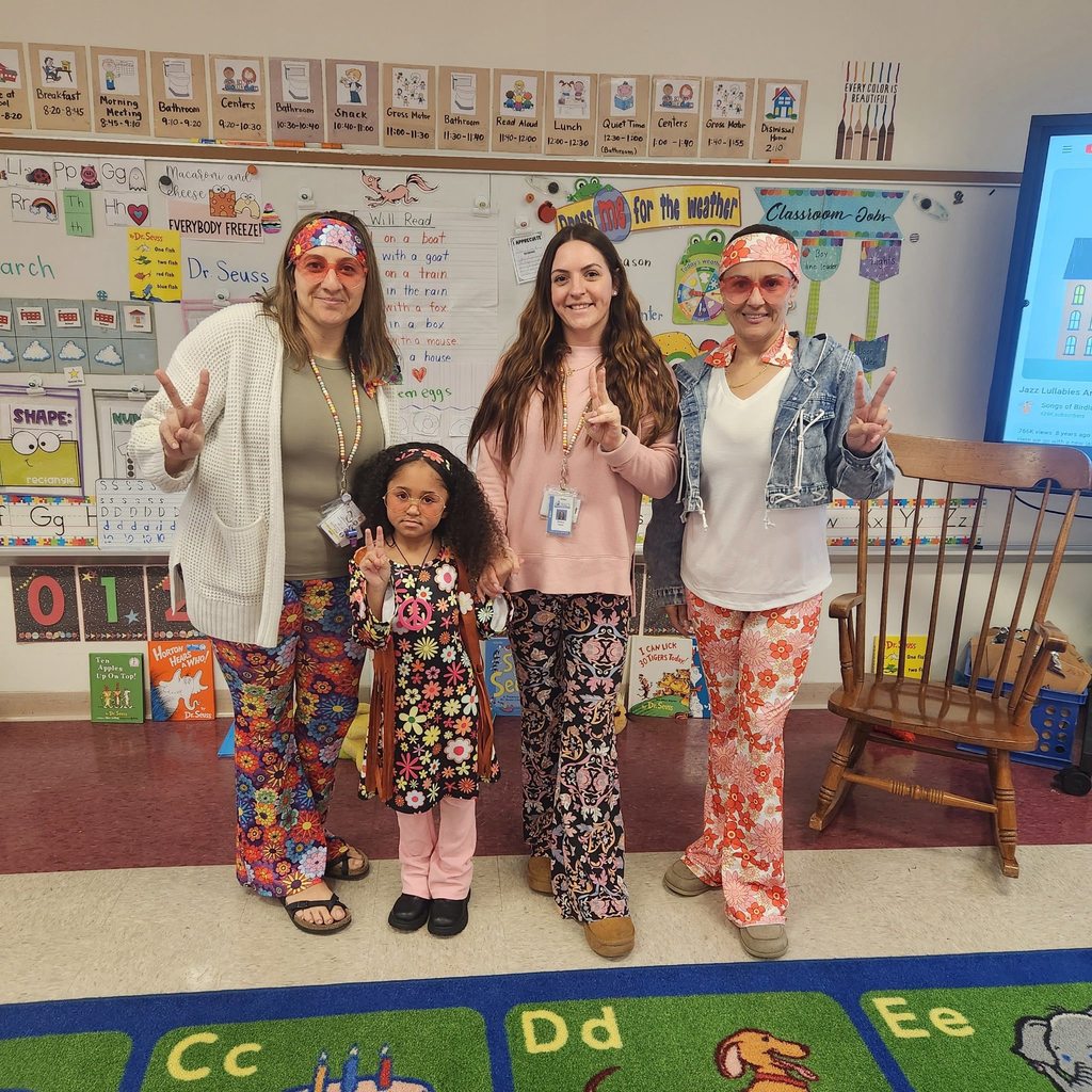 Teachers and a student dressed in 70's wear.