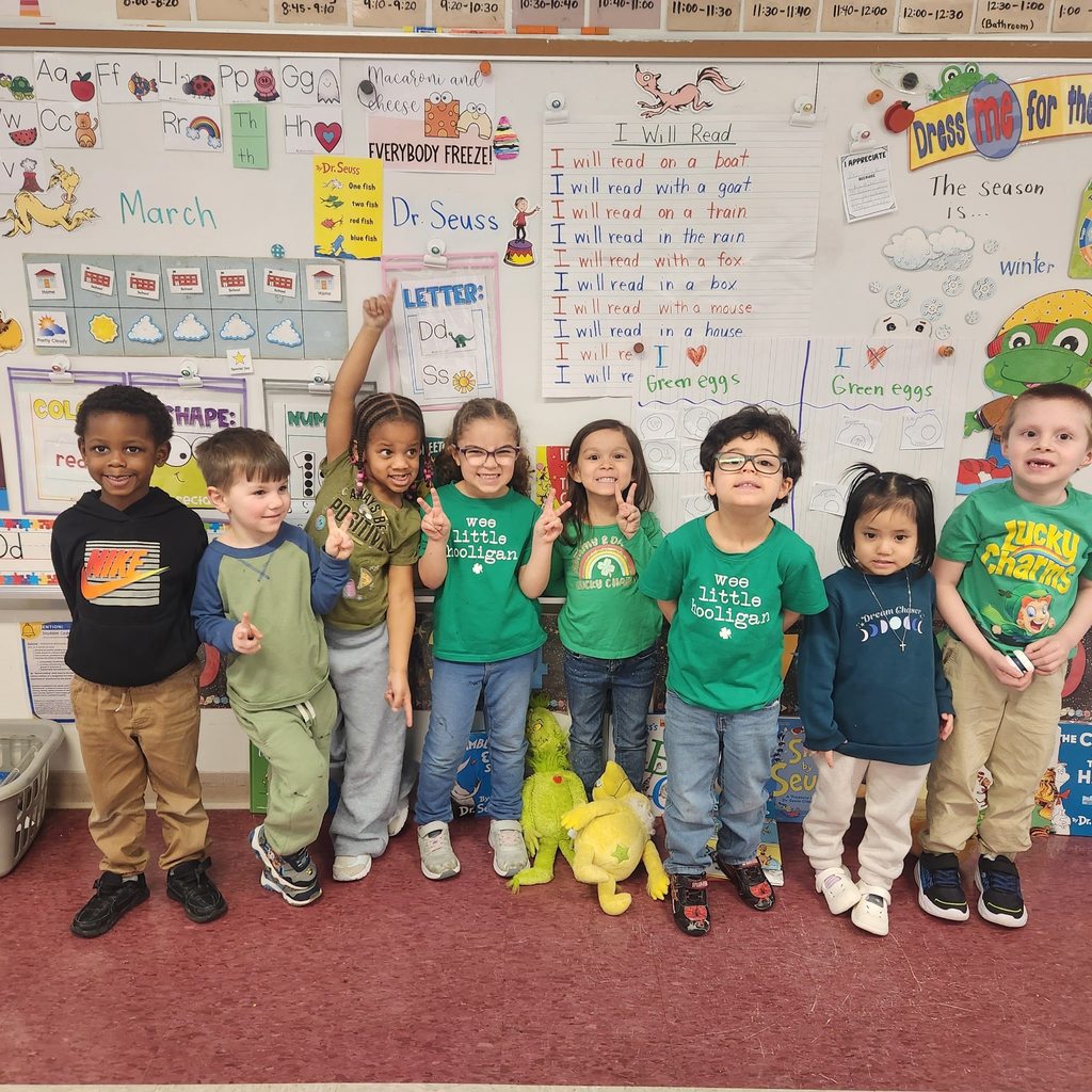 Students dressed in green and smiling. 