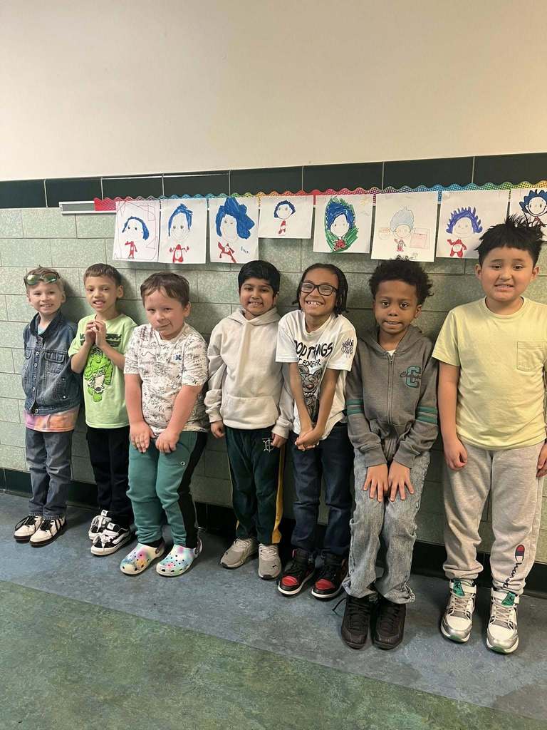 Students standing in the hall and smiling. 