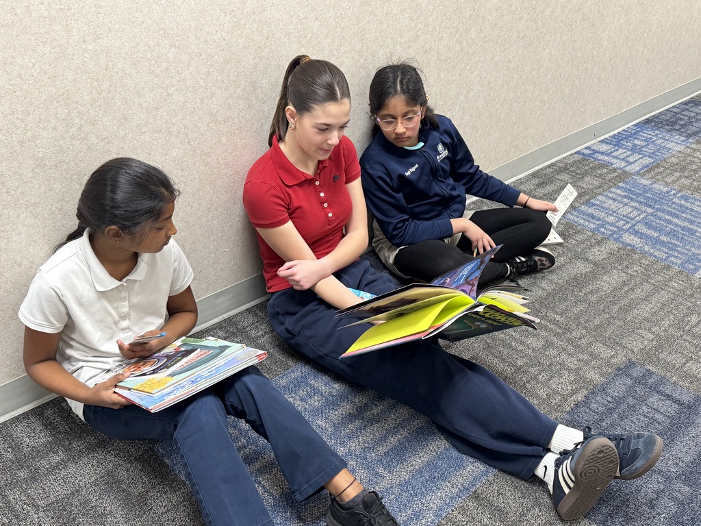 three girls reading in the hallway