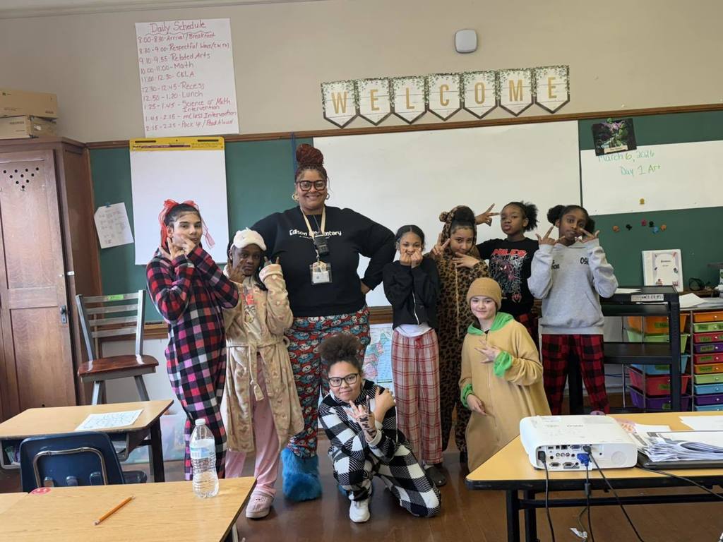 A teacher and students wearing pajamas in school.