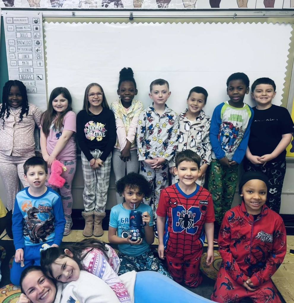 Students and teacher wearing pajamas and smiling.