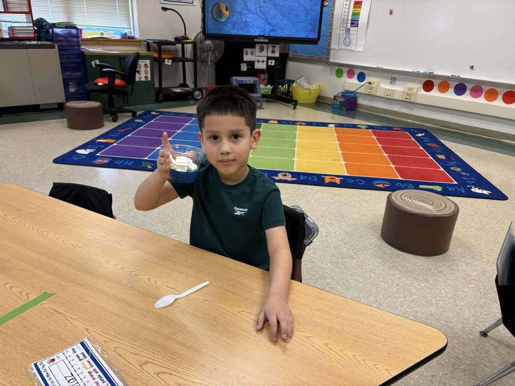A student holding their snack in a cup for Dr. Seuss week.