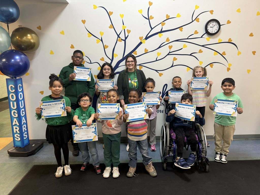 Students holding their certificates and an adult smiling with them. 