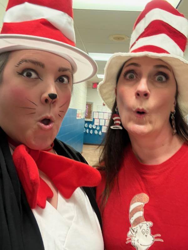 Two adults dressed like the Cat in the Hat. 