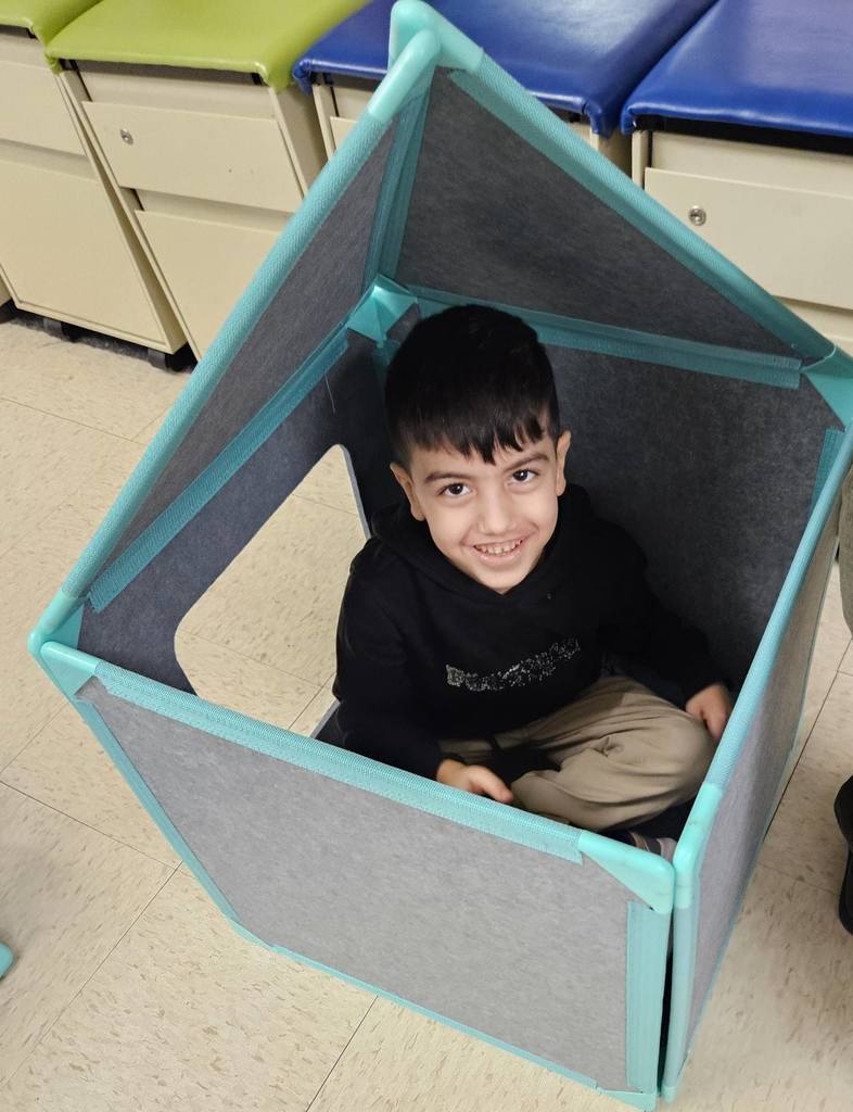 Kids building a house using fabric blocks. 