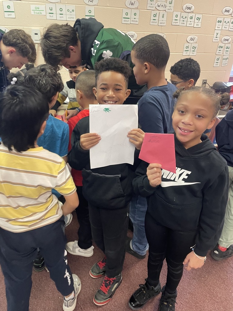 Students holding autographs they received from Mercyhurst University Football Players.