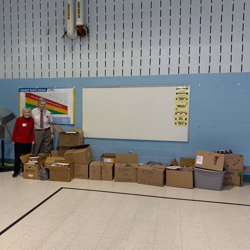 A man and women standing next to a lot of boxes. 