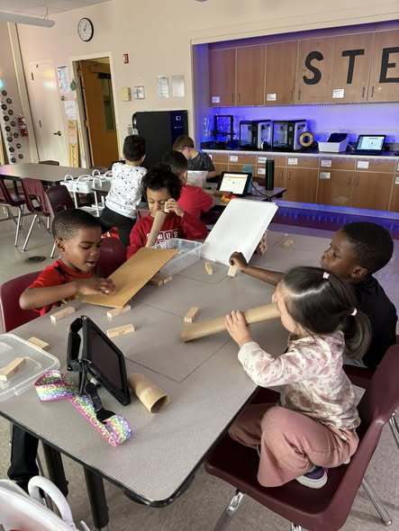 Kids playing with cardboard and rolls from paper towels. 