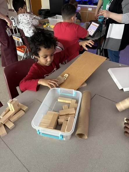 Kids playing with cardboard and blocks. 