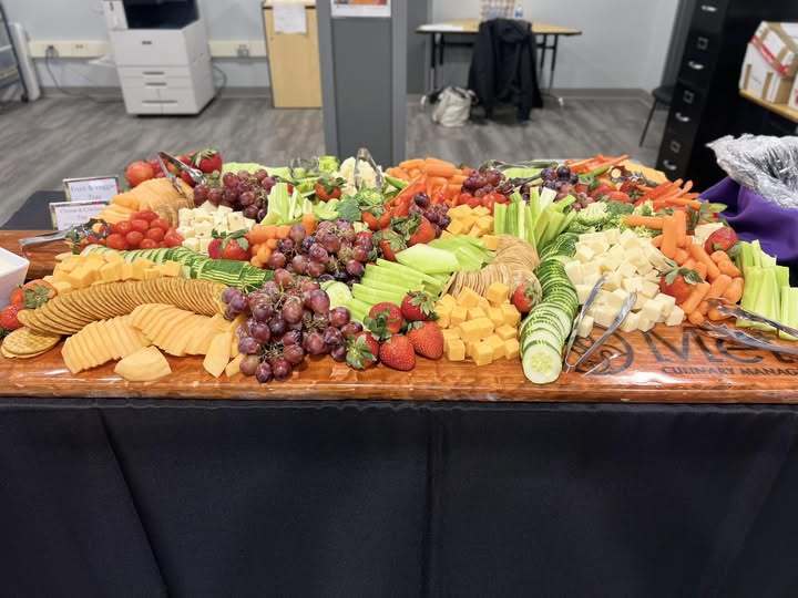 A table with fruit, vegetables, cheese, and crackers.