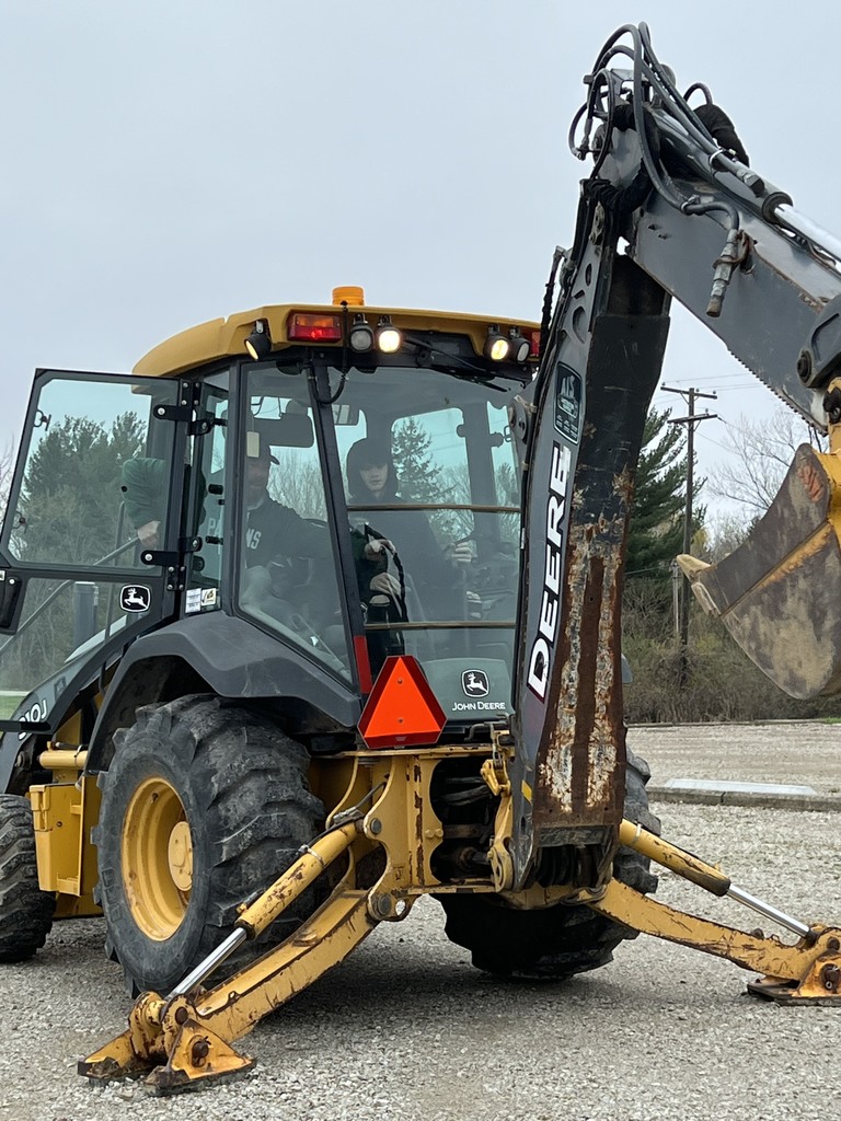 Student running a backhoe
