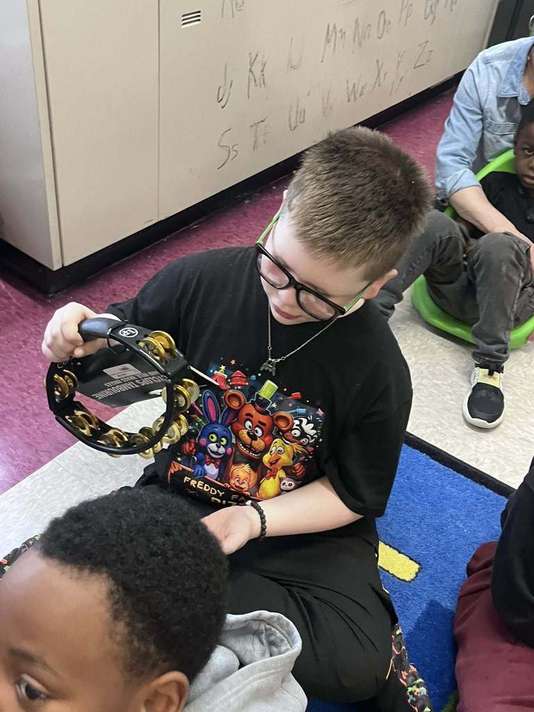 A student playing a tambourine. 