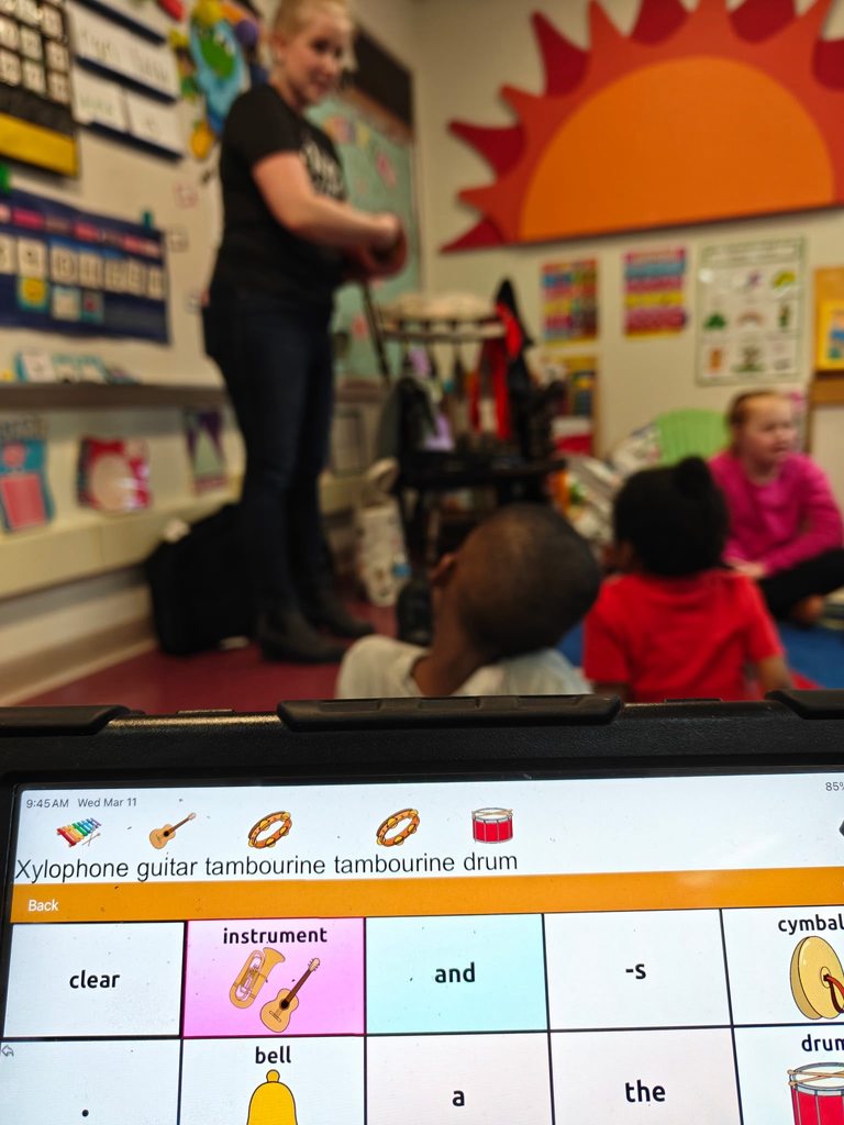 A computer screen showing instruments and students in the background. 