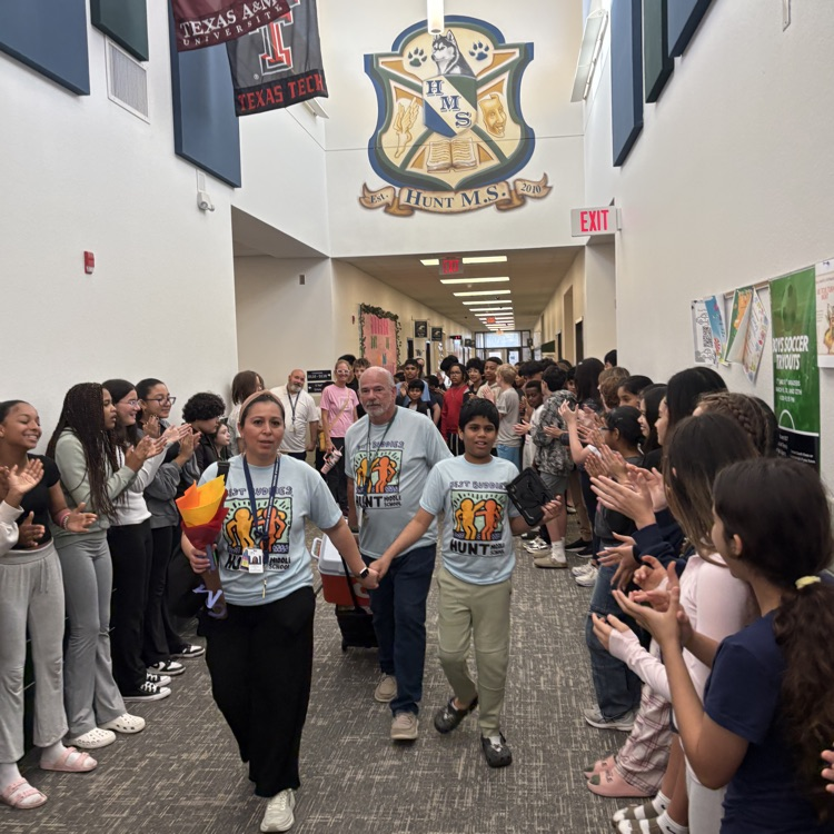 students lined the hallways cheering on a student and staff as they leave the building headed to Special Olympics