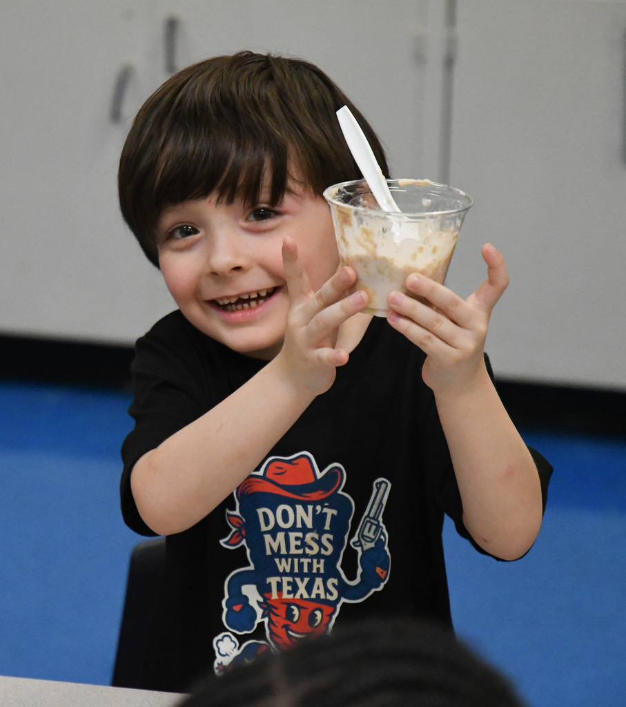 boy holding up a parfait he made