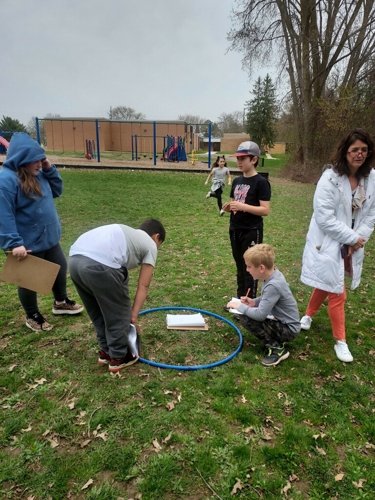 students and teacher outside looking at nature