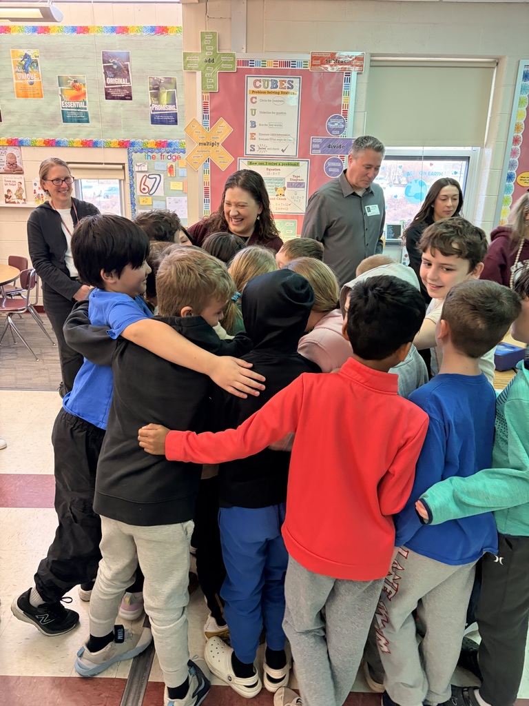 classroom students hugging teacher