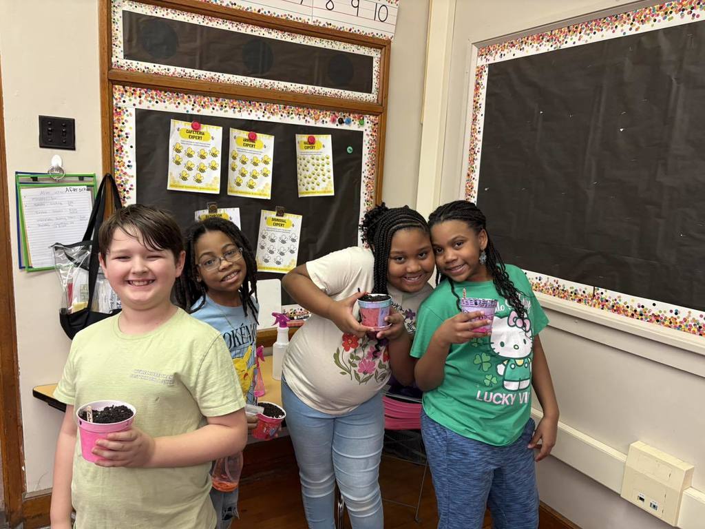Students smiling while they hold their planters. 