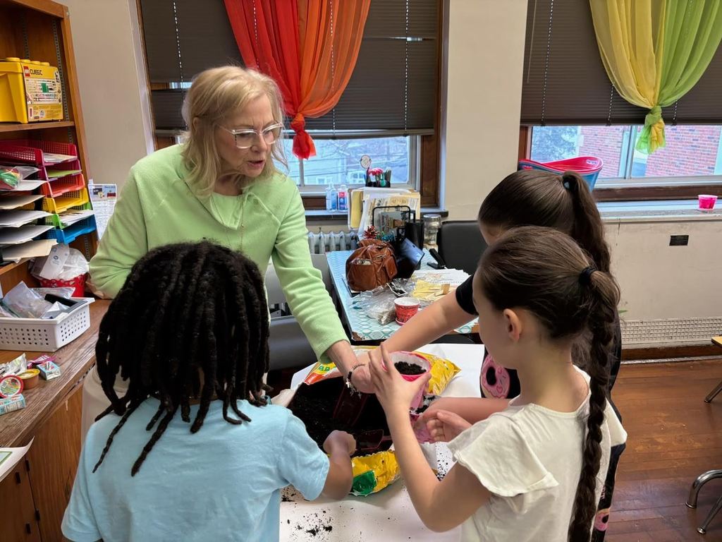 Students putting dirt in their containers to plant seeds. 